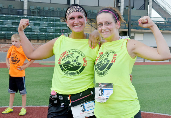 Rita-Riffie's Lissie King and Jeri Fincher celebrate their Amazing Race finish at David Allen Memorial Ballpark Friday, August 7, 2015. Eleven teams faced 100 degree temperatures during the first annual Paramount Realtors/Sandbox Learning Center event. (Staff Photo by BONNIE VCULEK)
